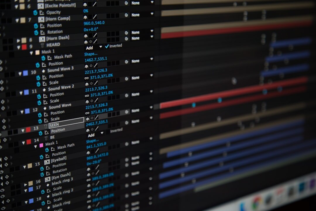 Video editing timeline with multiple tracks displayed on a computer monitor in a dim editing suite